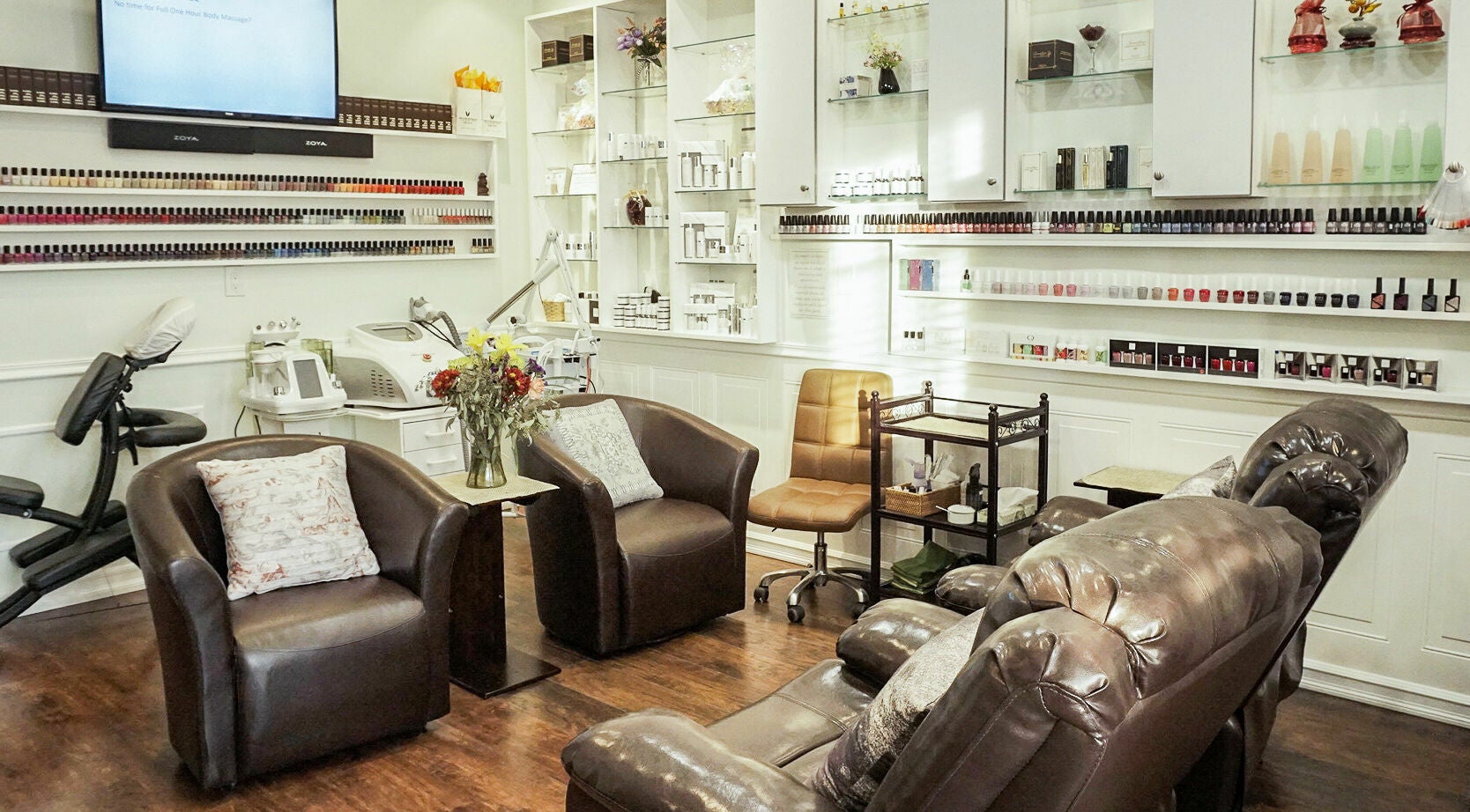 Relaxing nail salon at Pure Green Locust Valley, Locust Valley, New York, US, with brown leather chairs and nail polish display.