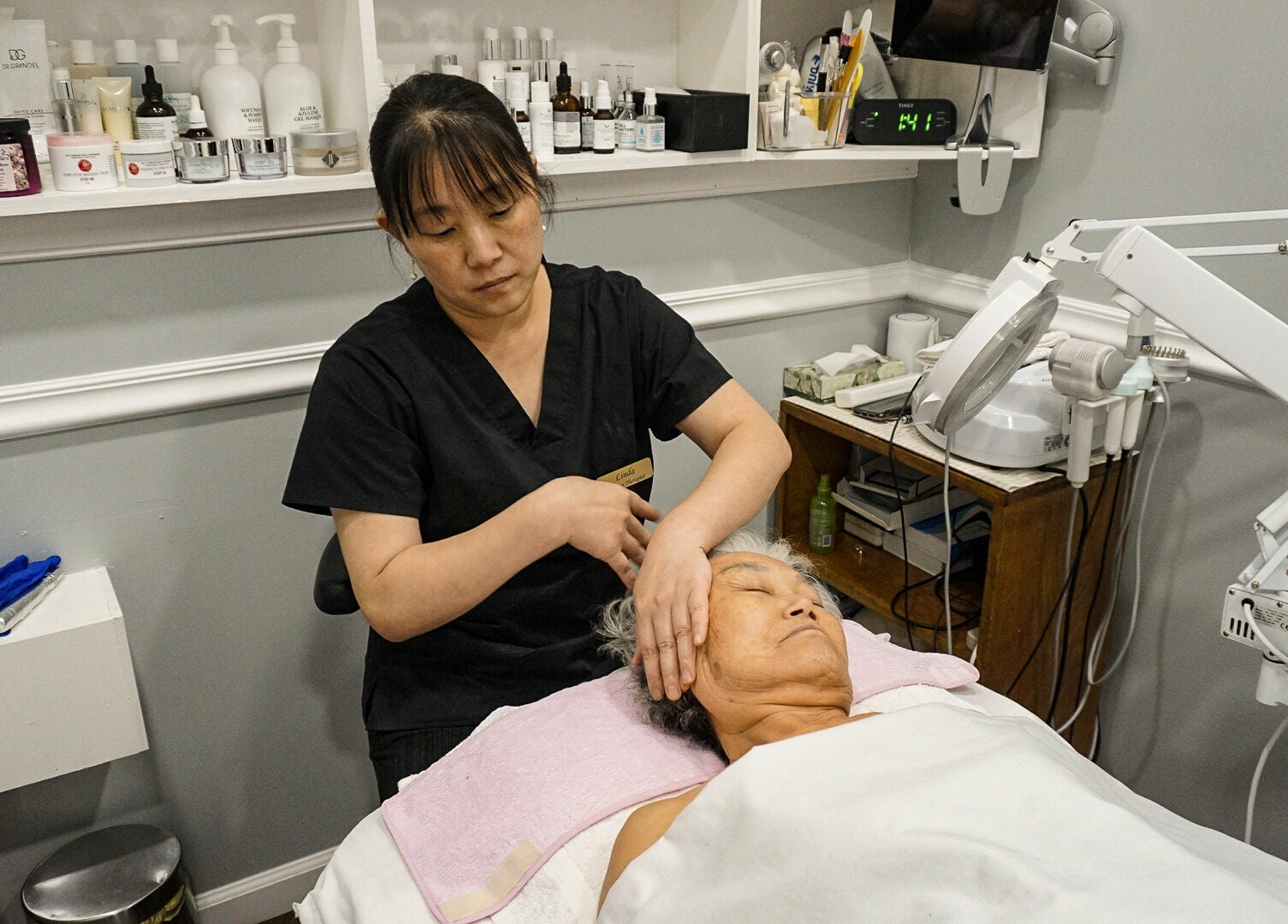 Facial treatment in progress at Pure Green Locust Valley, Locust Valley, New York, US with skincare products nearby.