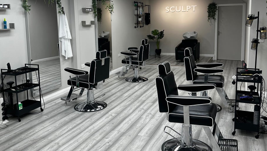 Modern interior of Sculpt salon in Newry, Northern Ireland, GB featuring sleek black chairs and mirrors.