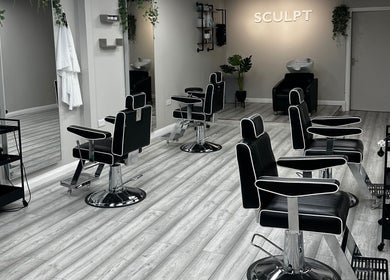 Modern interior of Sculpt salon in Newry, Northern Ireland, GB featuring sleek black chairs and mirrors.