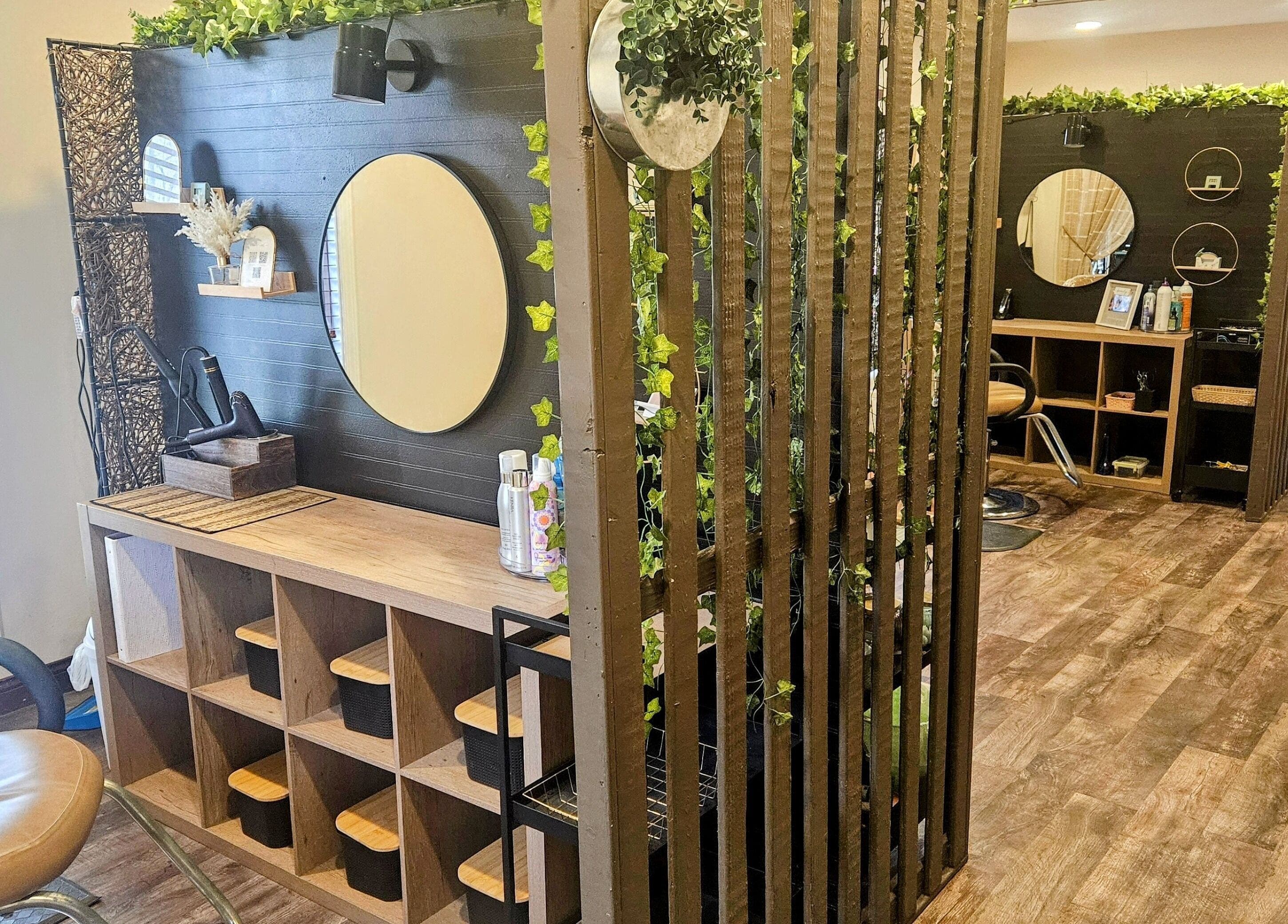 Elegant salon booth at Simply Suite, Lima, Ohio, US, featuring mirrors, wood accents, and plants.