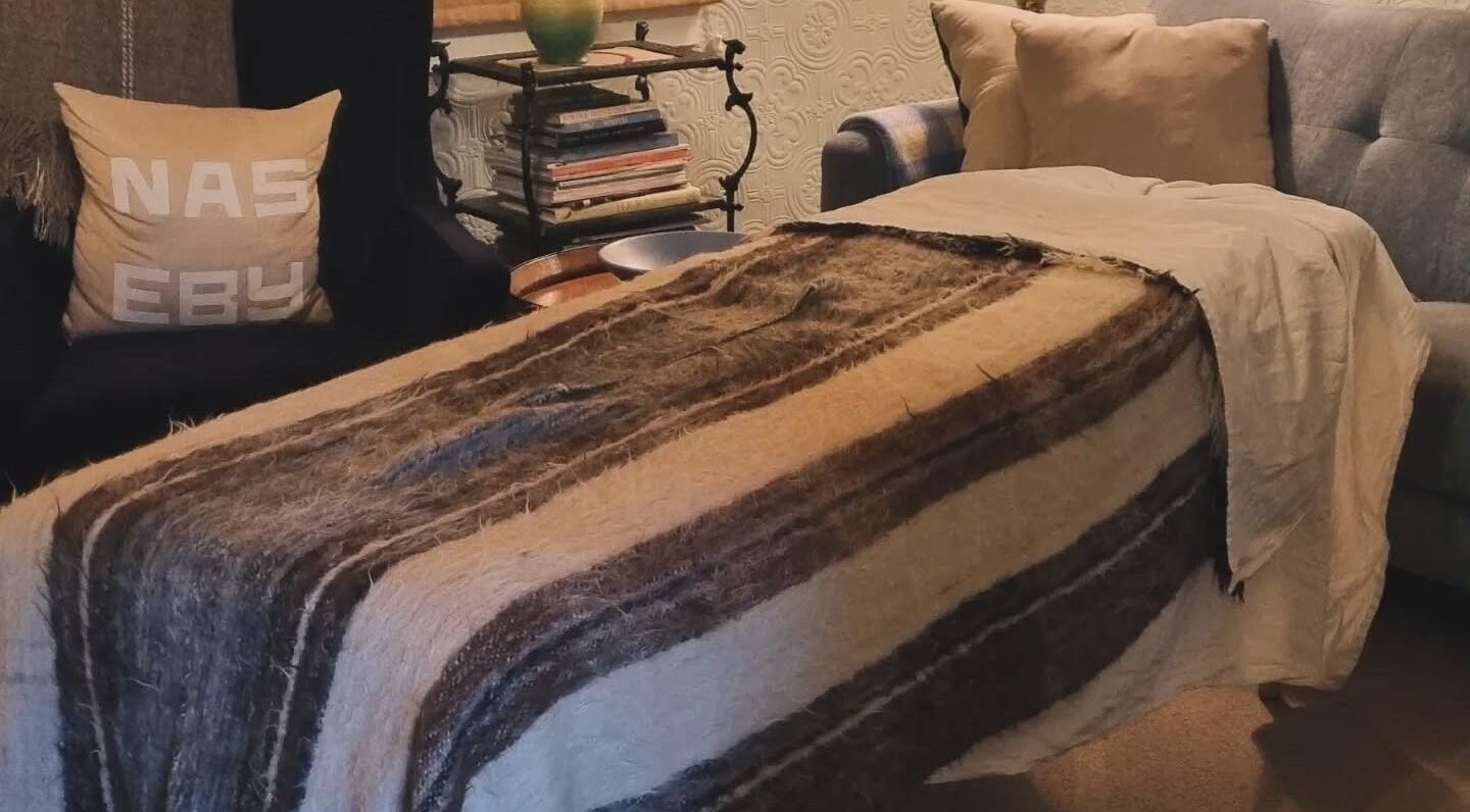 Cozy lounge area at Self Mind & Body, Dunedin, Otago, NZ, featuring plush seats and a warm throw.