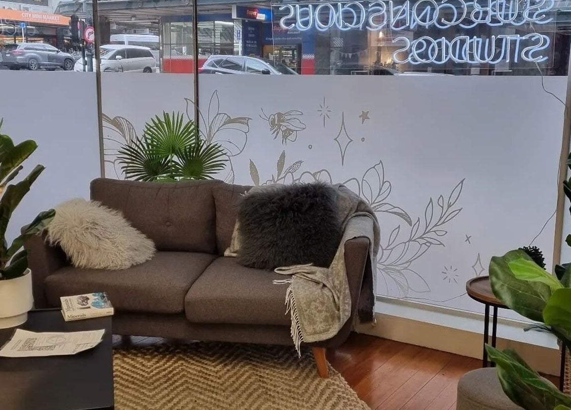 Relaxing seating area at Self Mind & Body, Dunedin, Otago, NZ with a plush sofa and vibrant plants.