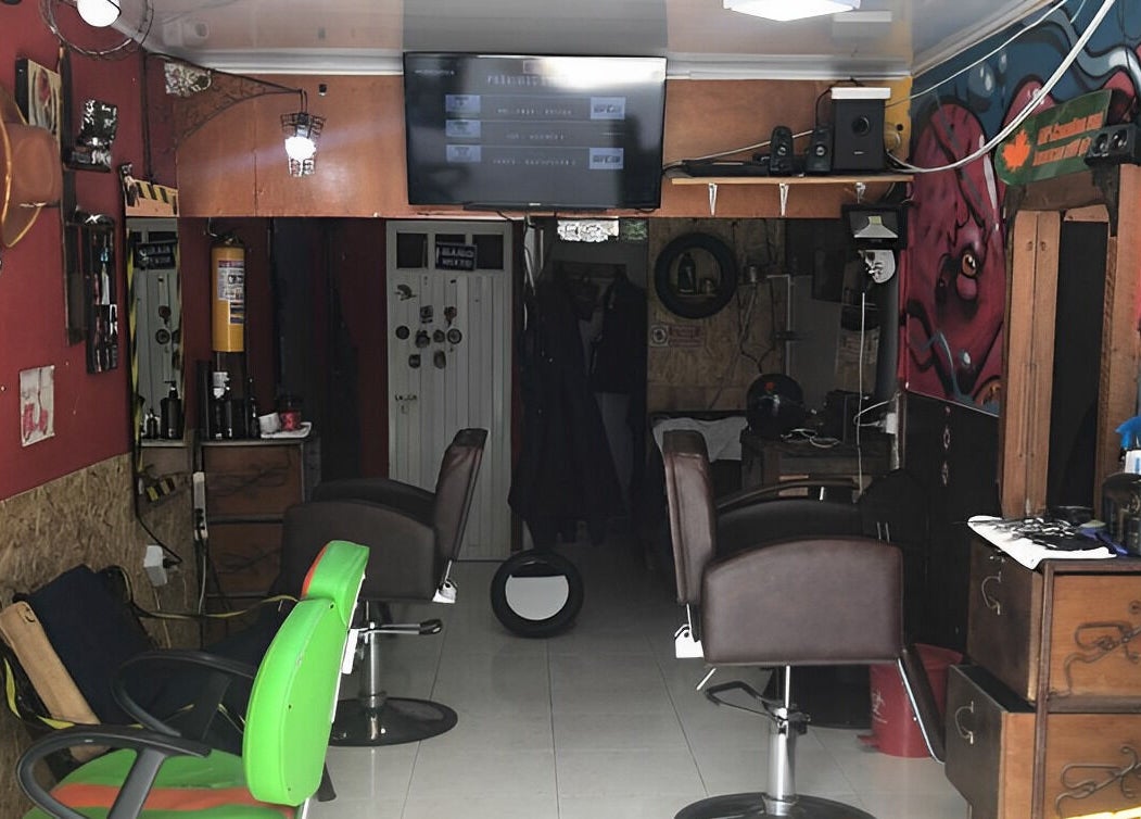 Interior del salón de belleza Cut Art Sam Bigotes en Bogotá, Bogotá, CO con sillas modernas y decoración colorida.