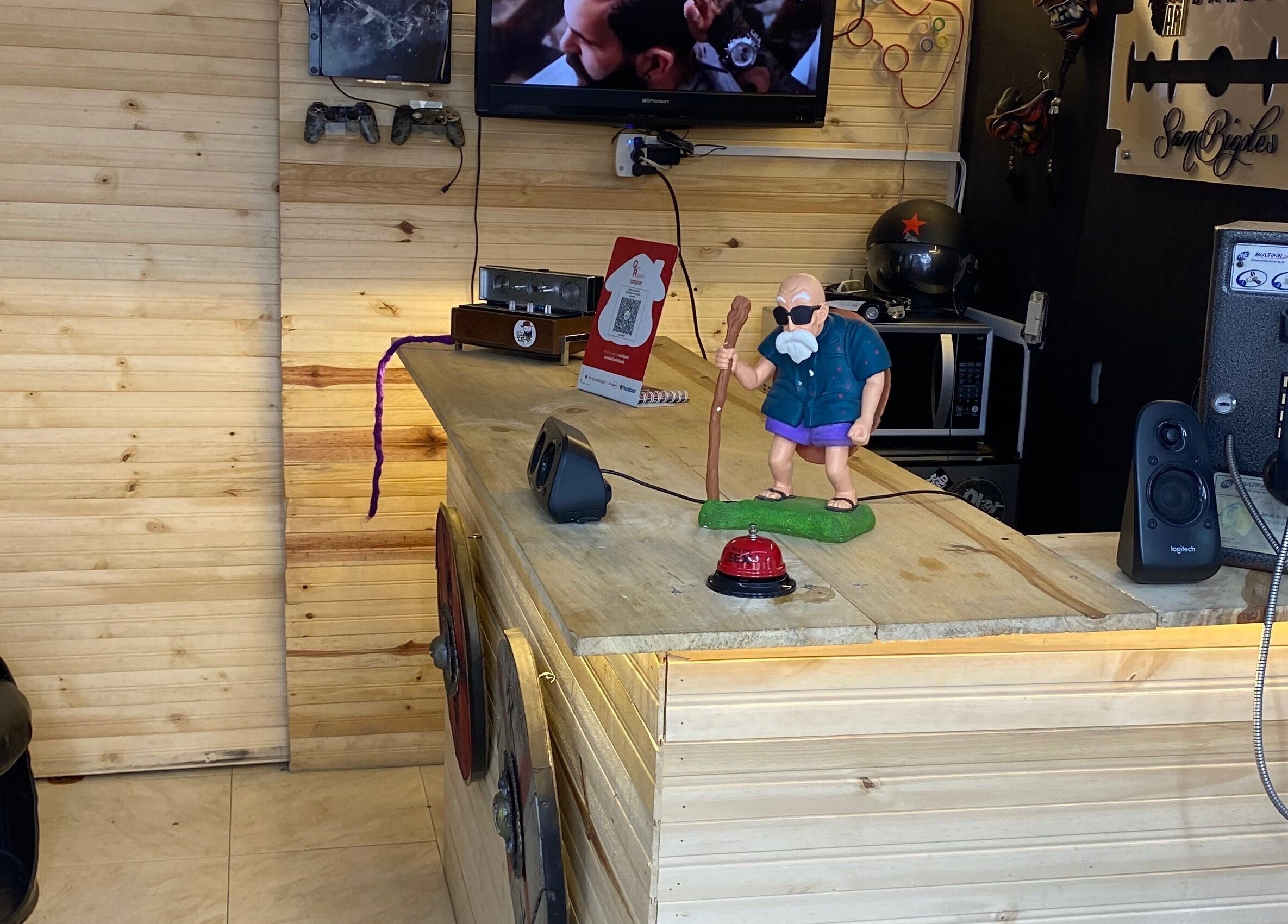 Mostrador de madera en Cut Art Sam Bigotes, Bogotá. Decoración retro con teléfono antiguo y figura animada.