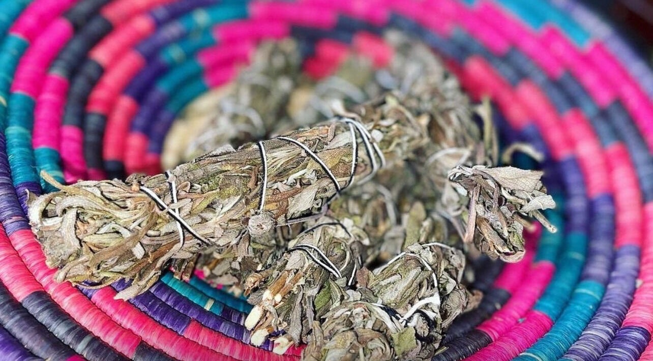 Dried sage bundles curled on vibrant woven mat at Black Roses Spiritual Awareness, Columbia, South Carolina, US.