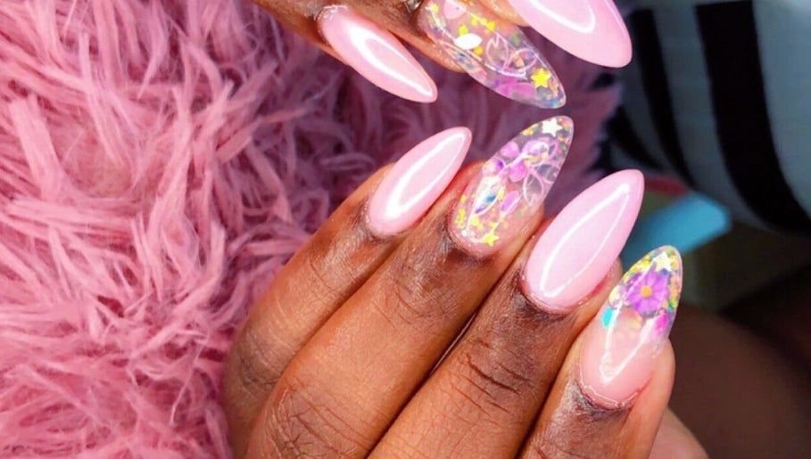 Vibrant floral nail art at Kreative Tips and Toes, Providenciales, TC, showcasing intricate designs on pink nails.