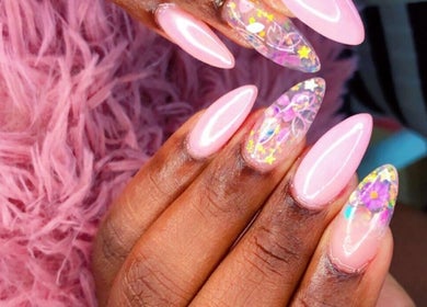 Vibrant floral nail art at Kreative Tips and Toes, Providenciales, TC, showcasing intricate designs on pink nails.