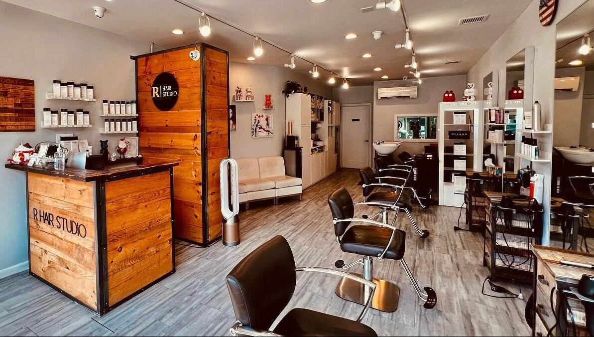 Interior of R Hair Studio, New York, New York, US, showcasing modern salon chairs and product displays.