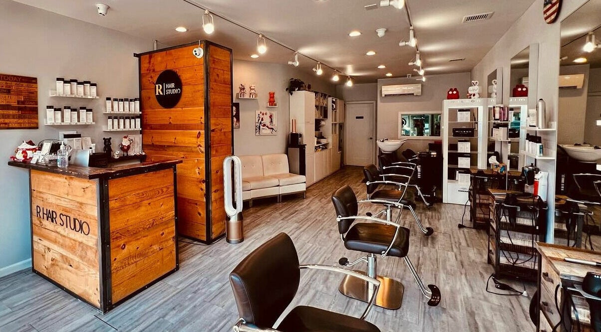 Interior of R Hair Studio, New York, New York, US, showcasing modern salon chairs and product displays.