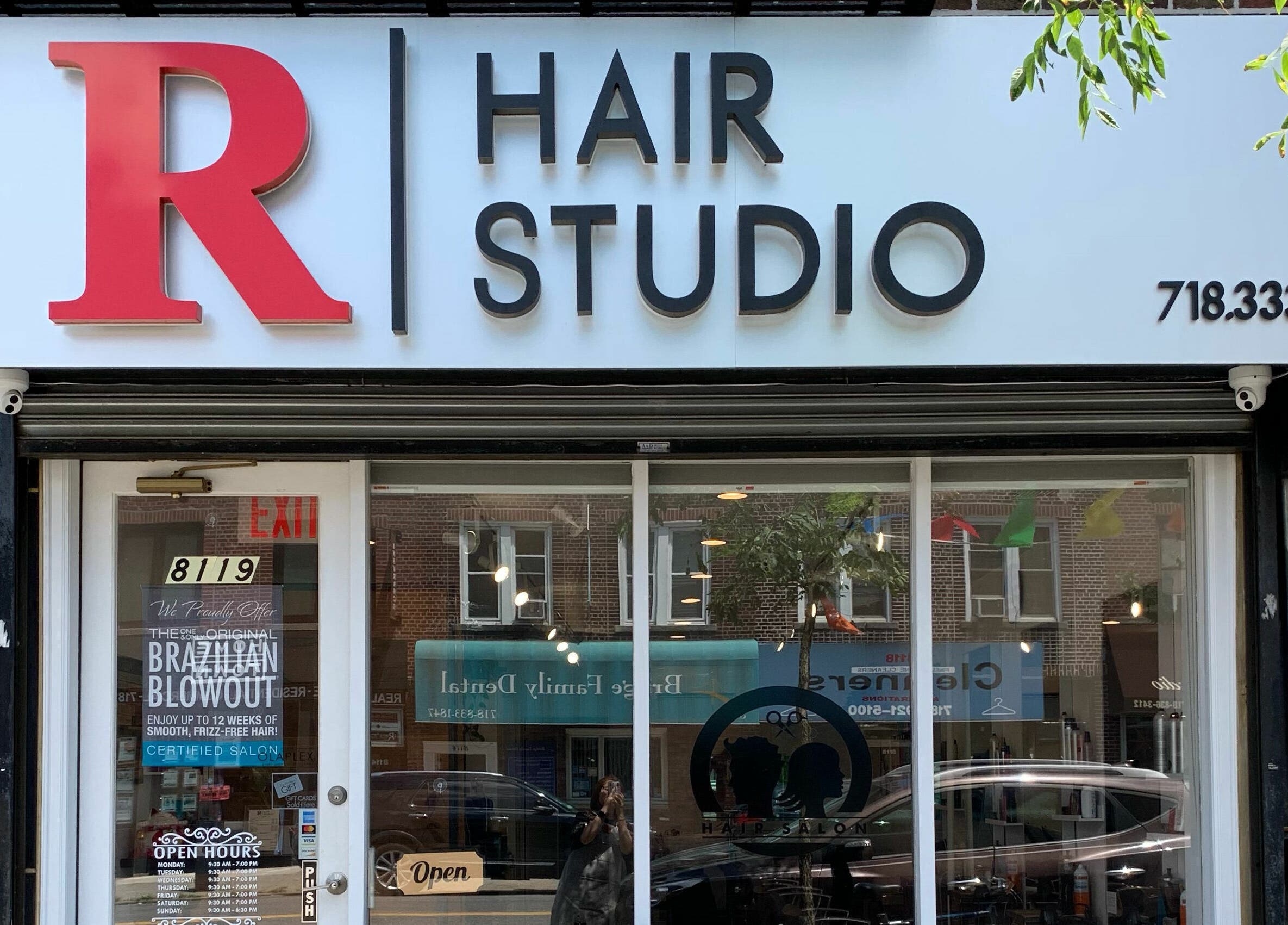 Front view of R Hair Studio in New York, New York, US with stylish signage.