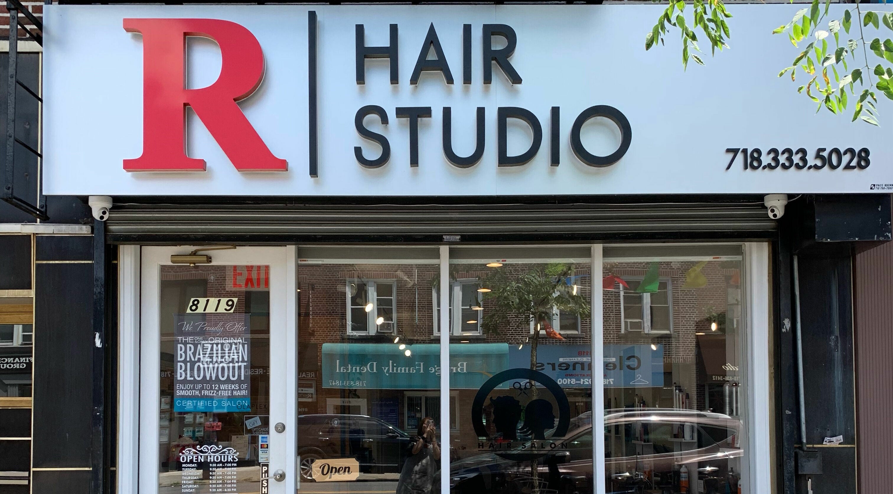 Front view of R Hair Studio in New York, New York, US with stylish signage.