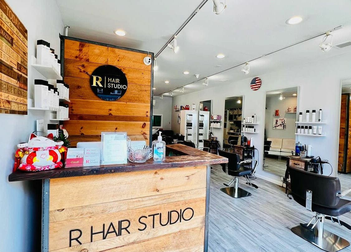 Modern interior of R Hair Studio in New York, New York, US featuring stylish workstations and decor.