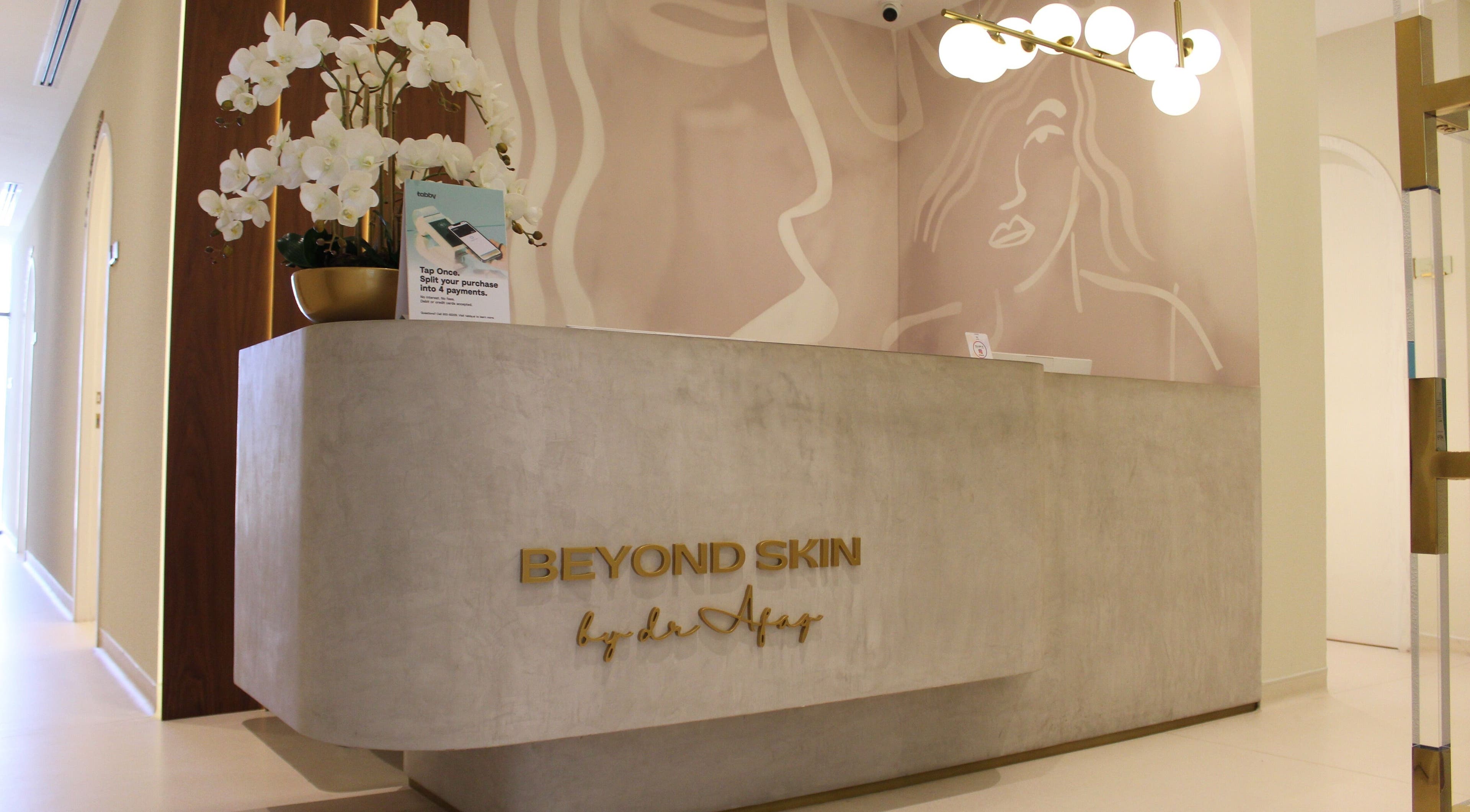 Chic reception desk at Beyond Skin Clinic, Dubai, AE, with floral decor and ambient lighting.