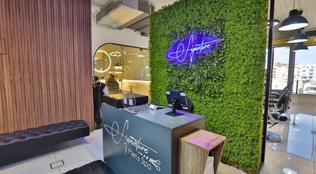 Reception at Signature Men's Spa By Mostafa, Amman features a vibrant green wall and modern decor.