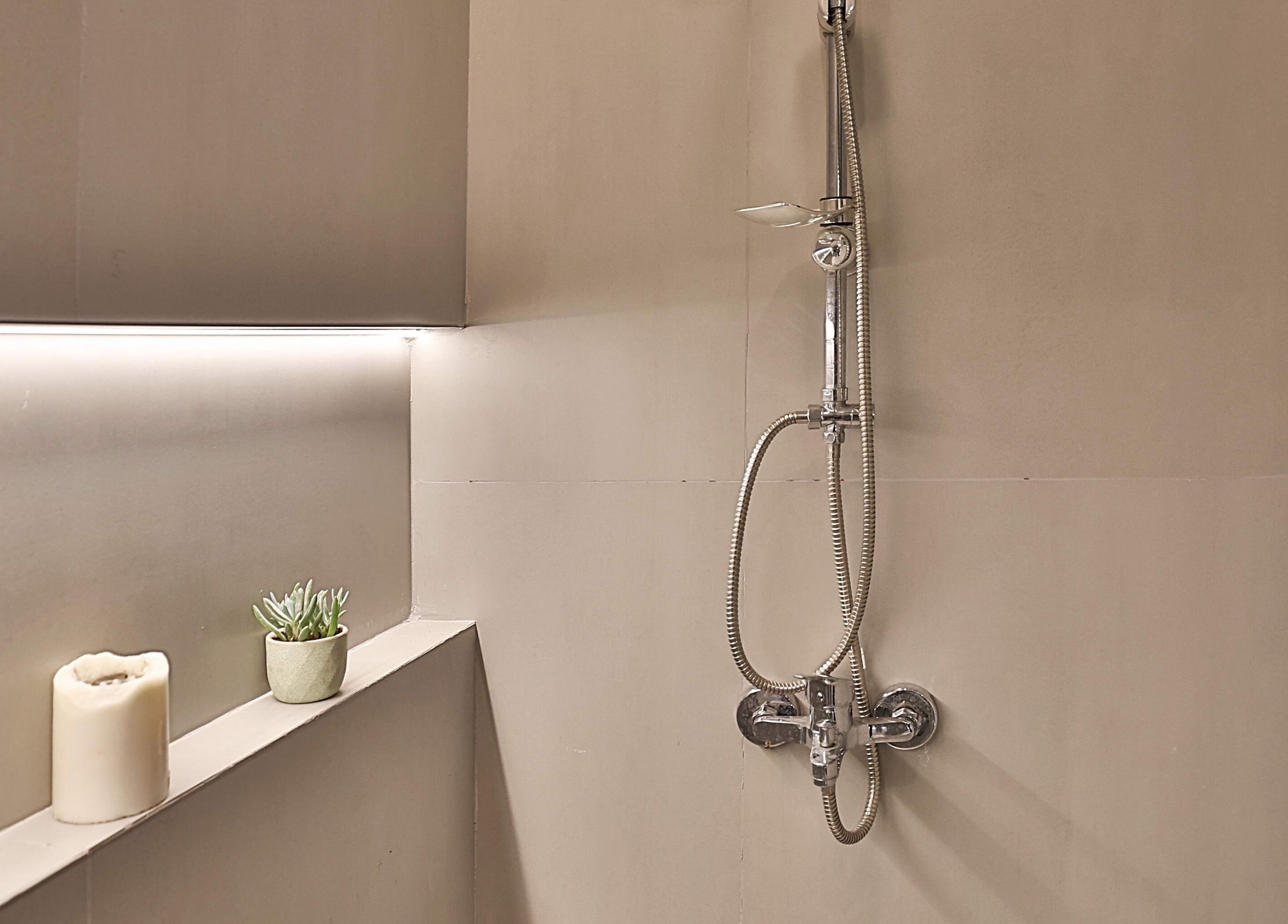 Sophisticated shower at Signature Men's Spa By Mostafa, Amman, Amman Governorate, JO, with candle and plant.