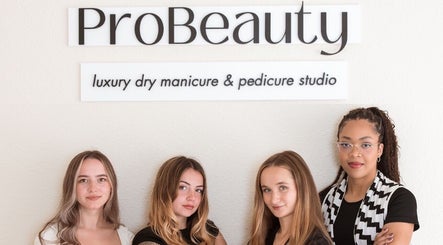 Team at ProBeauty in Virginia Beach, Virginia, US in front of the studio sign.