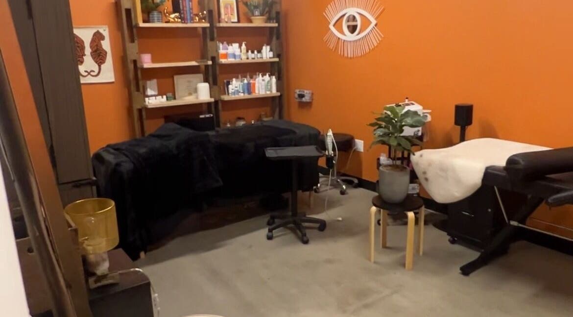 Warm, inviting treatment room at Lemon's Esthetics Studio in South Jordan, Utah, US with orange walls and plush beds.