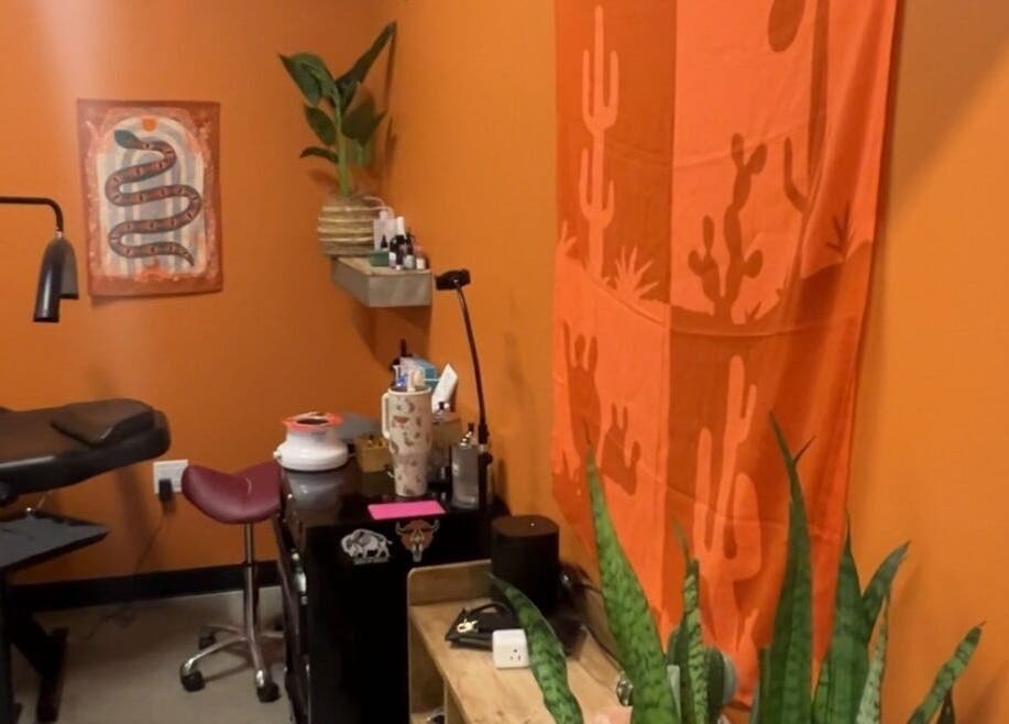 Inviting, cozy room at Lemon's Esthetics Studio, South Jordan, Utah, US with warm orange decor and plants.