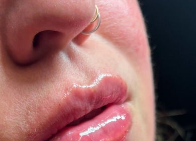 Close-up of glossy lips with a nose ring at Ivy Beauty Lounge @ Cloud Nine, Chesterfield, England, GB.