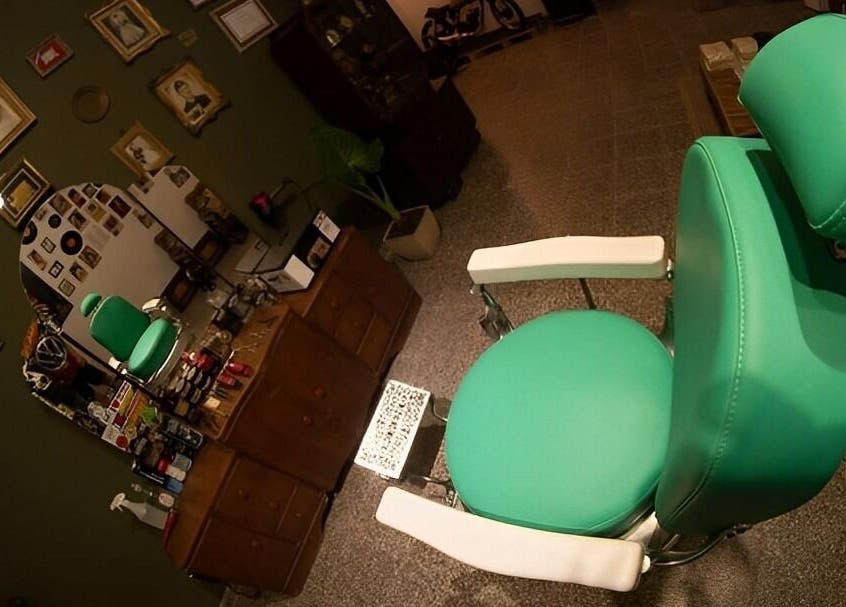 Silla verde en Barberia Dandy, Cañada De Gomez, Santa Fe, AR, decorada con fotos vintage.