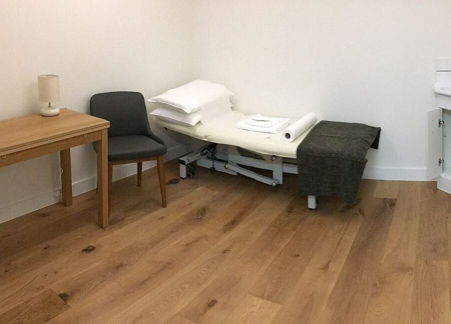 A tranquil therapy room at Danugur Monument, London, England, GB with a massage table and calming decor.