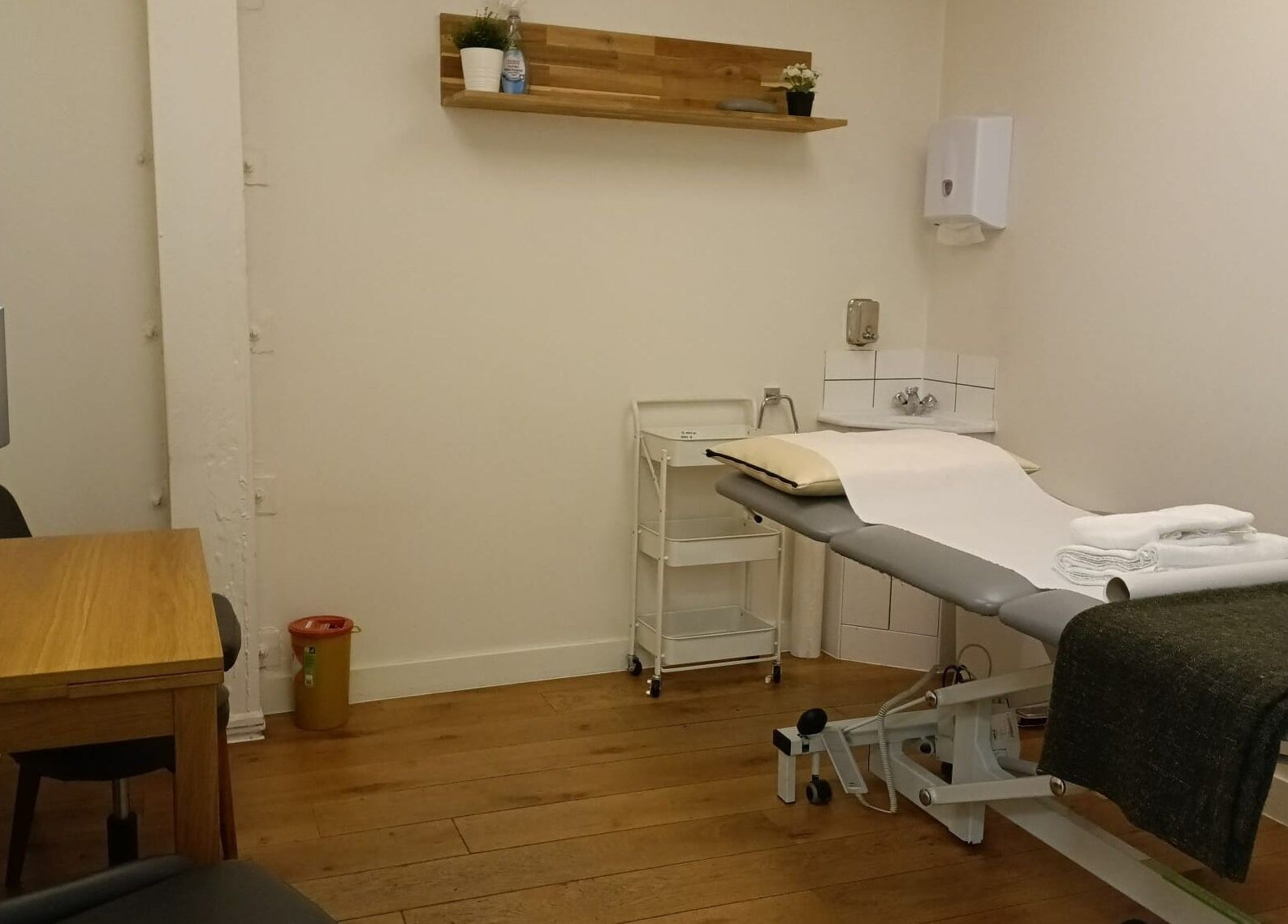 Cozy wellness treatment room at Danugur Monument, London, England, GB, featuring a massage table and warm decor.