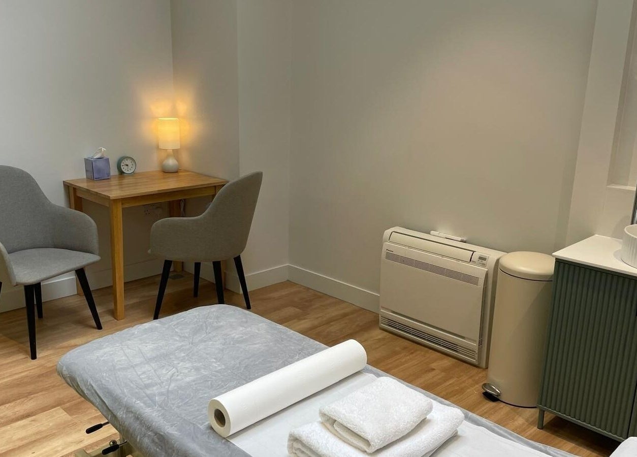 Tranquil treatment room at Maen (Men) Old Street, London, England, GB featuring massage table and cozy seating.
