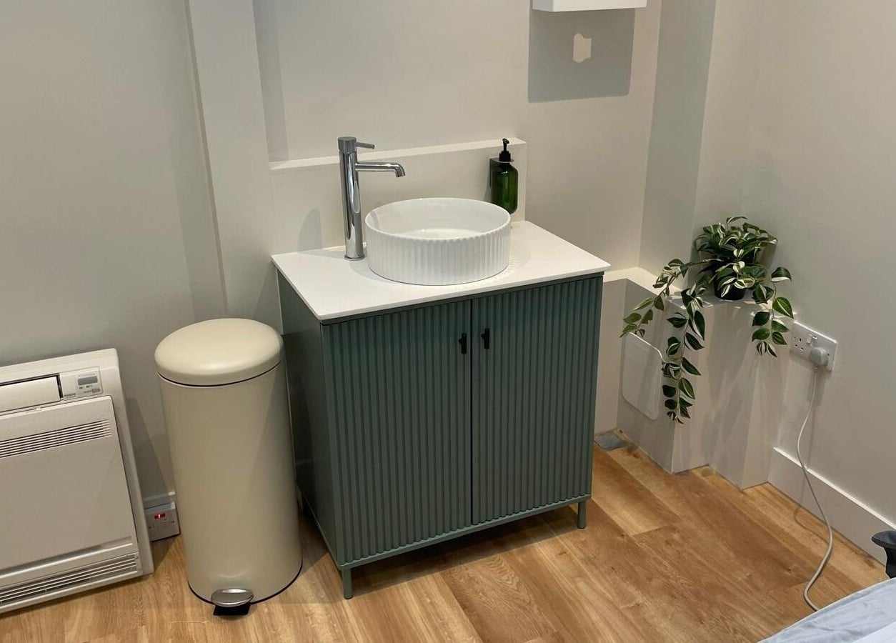 Elegant wash area at Maen (Men) Old Street in London, England, GB with modern fixtures and potted plant.
