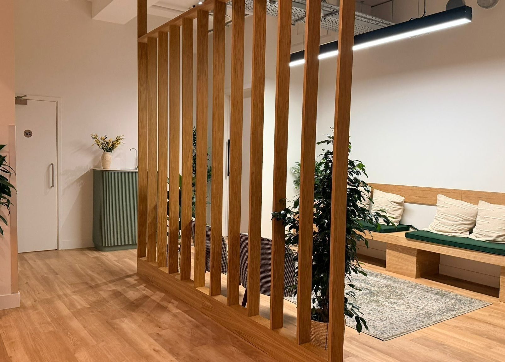 Tranquil lounge at Maen Men Old Street, London, England with wooden decor and green plants.