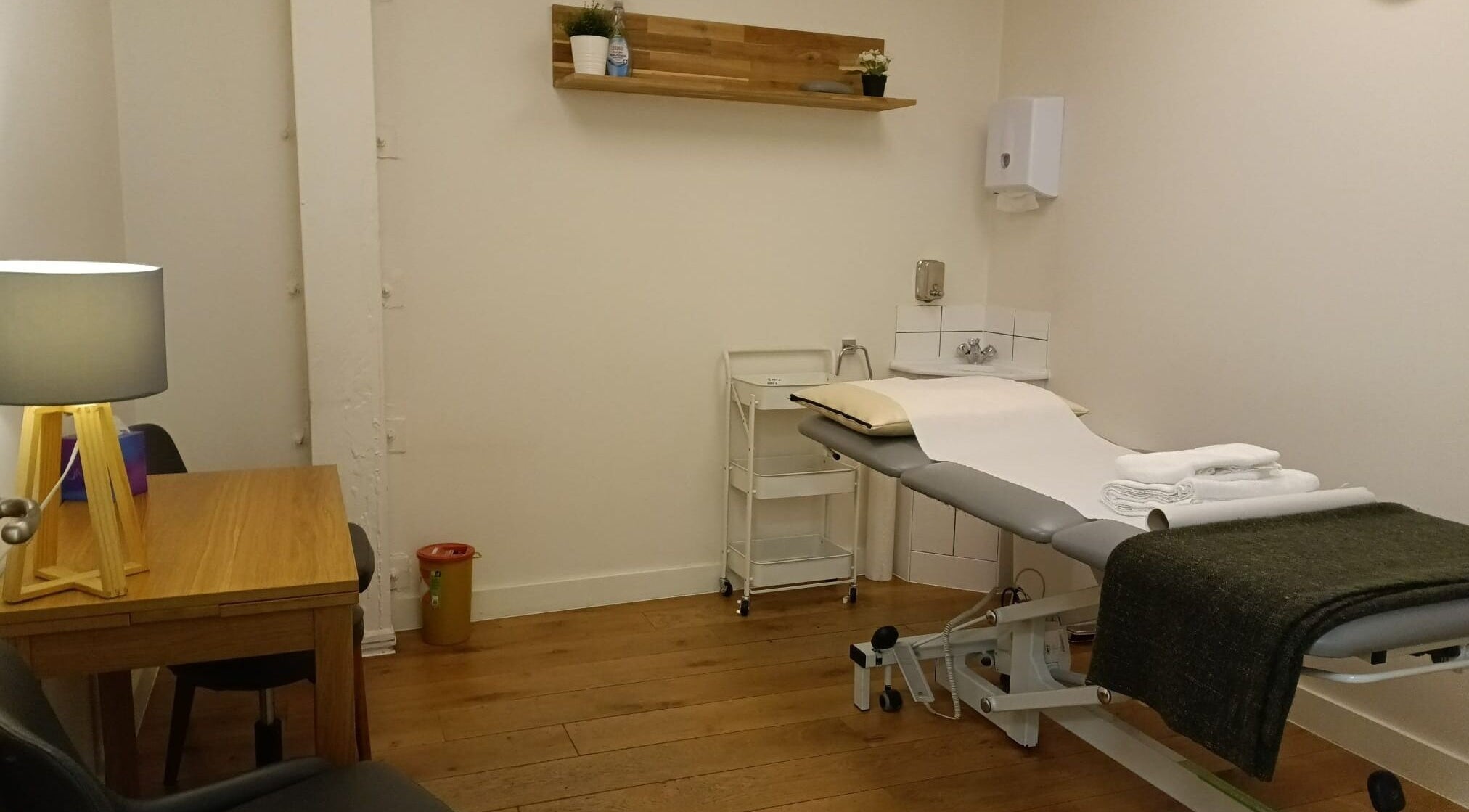 Calm treatment room at Maen Monument, London, England, with a massage table and soothing decor.