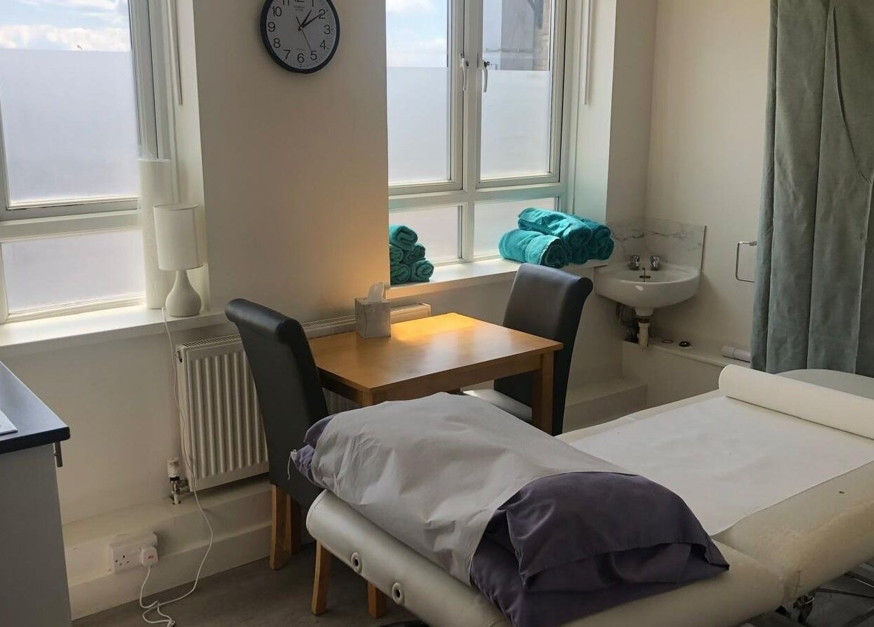 A soothing treatment room at Maen (Men) London Clapham in London, England, GB with massage table and towels.