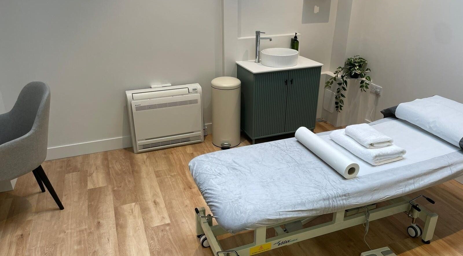 Modern treatment room at Maen (Men) Old Street, London, England, GB with massage bed and sink area.