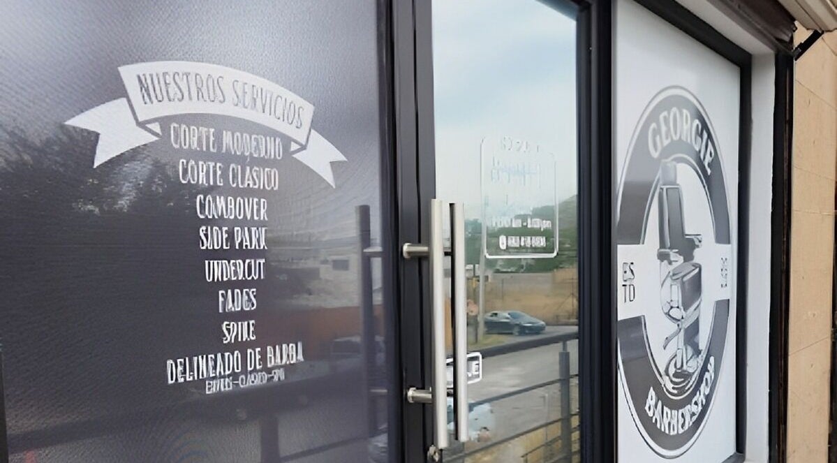 Entrada de Georgie Barbershop en Hermosillo, Sonora, MX, mostrando servicios y logotipo.