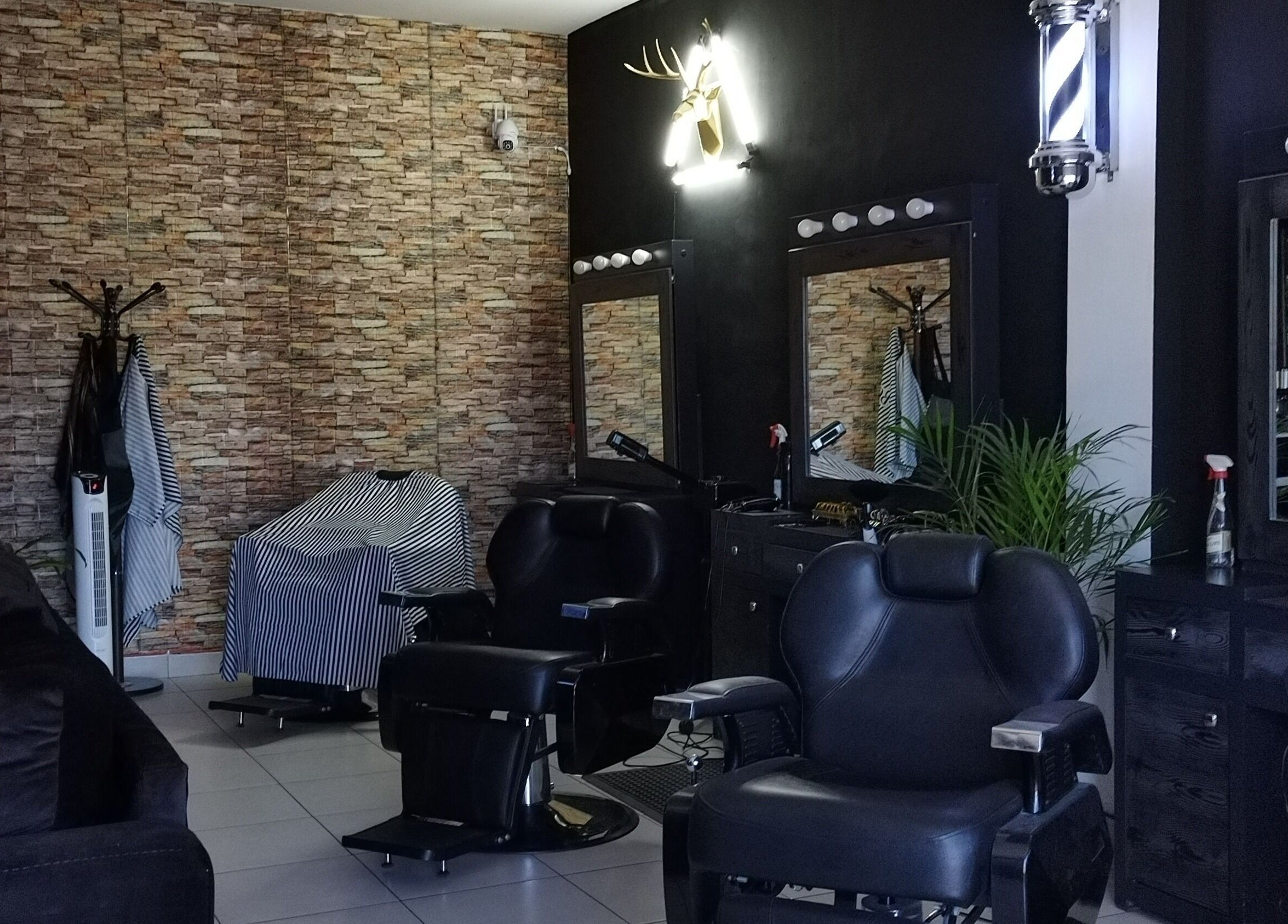 Interior de Georgie Barbershop, Hermosillo, Sonora, MX con sillas de barbería y decoración moderna.