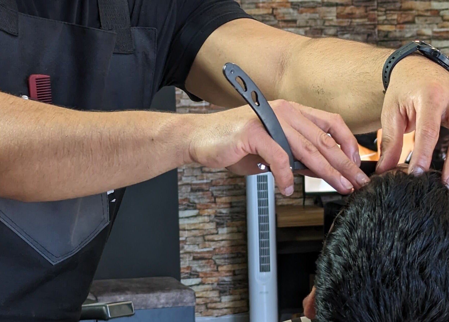 Estilista realiza corte preciso en Georgie Barbershop, Hermosillo, Sonora, MX.