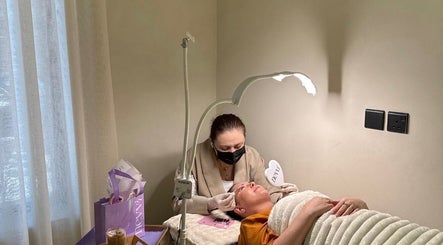 Aesthetician performing a facial treatment at Nevvi Beauty Salon, Riyadh, SA in a serene, softly lit room.