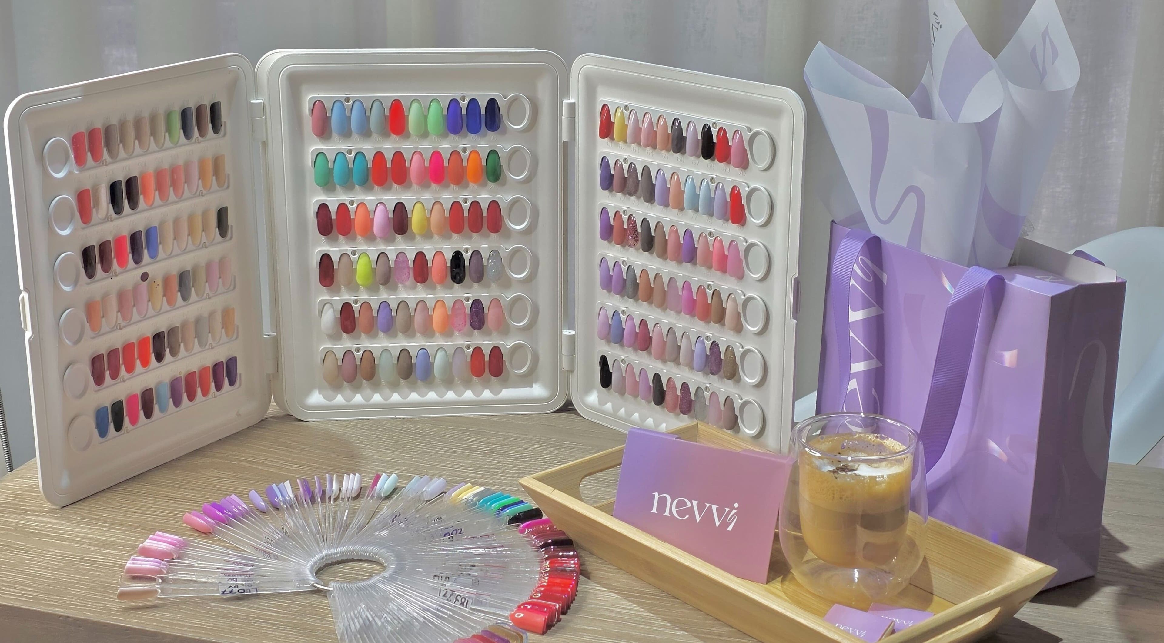 Nevvi Beauty Salon in Riyadh, SA showcases a vibrant nail color palette with purple gift bags and coffee.