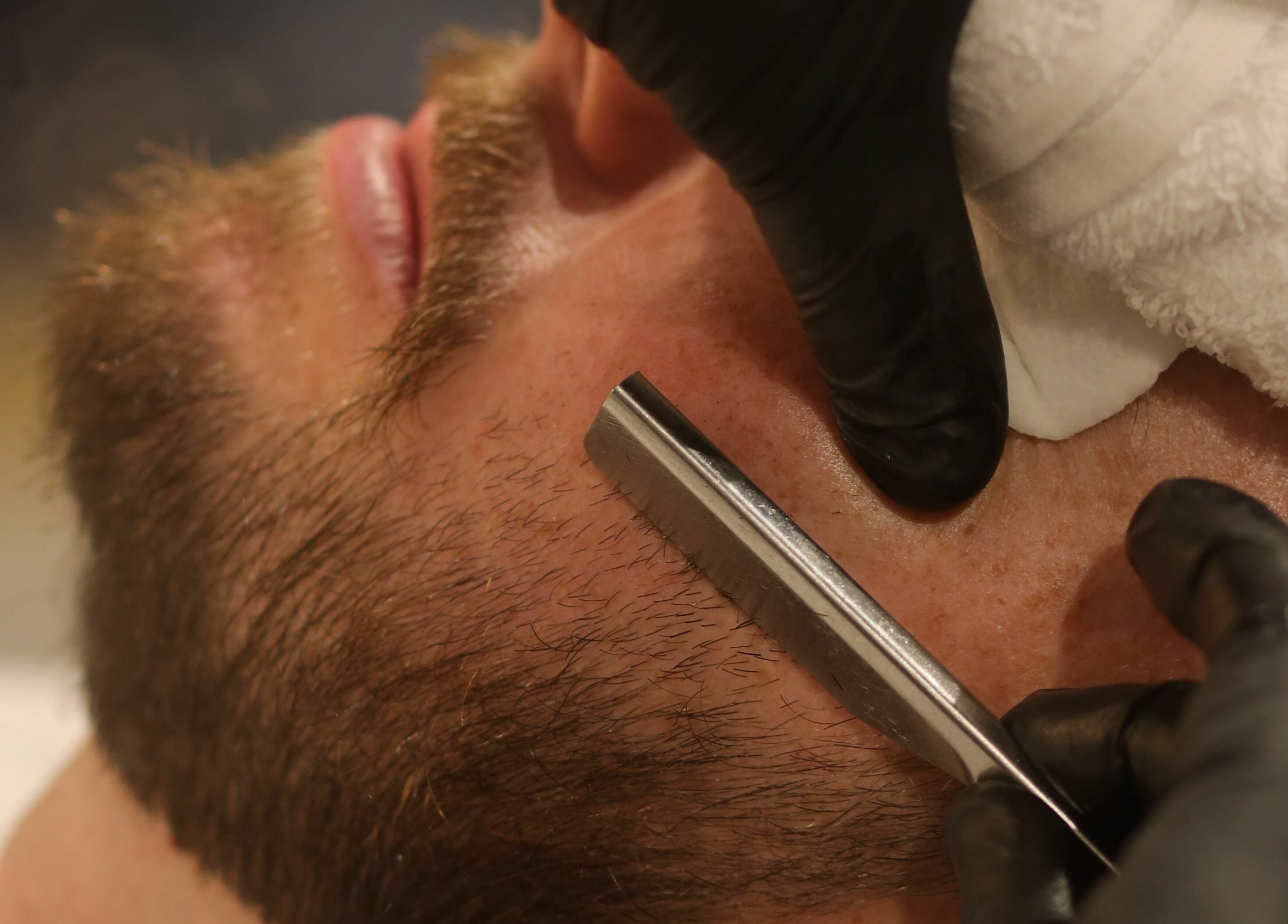 Close-up of beard shave at Shave Barbers - City Walk, Dubai, Dubai, AE with precision razor and skilled hand.