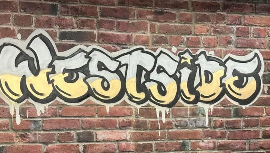 Colorful Westside mural on brick wall at Westside Beauty & Barbershop in Dunkirk, Indiana, US.