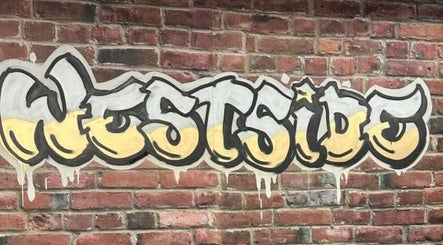 Colorful Westside mural on brick wall at Westside Beauty & Barbershop in Dunkirk, Indiana, US.