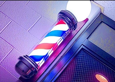 Radiant barber pole outside Westside Beauty & Barbershop, Dunkirk, Indiana, US, symbolizing classic grooming elegance.