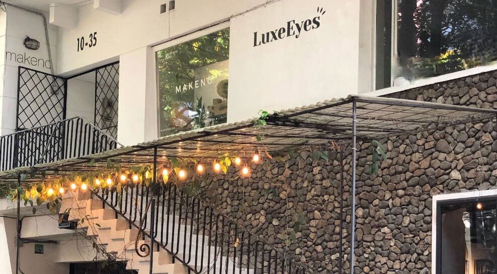 Luxe Eyes entrance with stone wall and string lights in Medellín, Antioquia, CO.