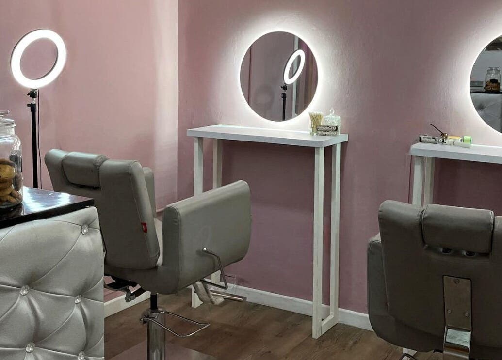 Luxe Eyes salon styling station in Medellín, Antioquia, CO featuring modern chairs and illuminated mirrors.