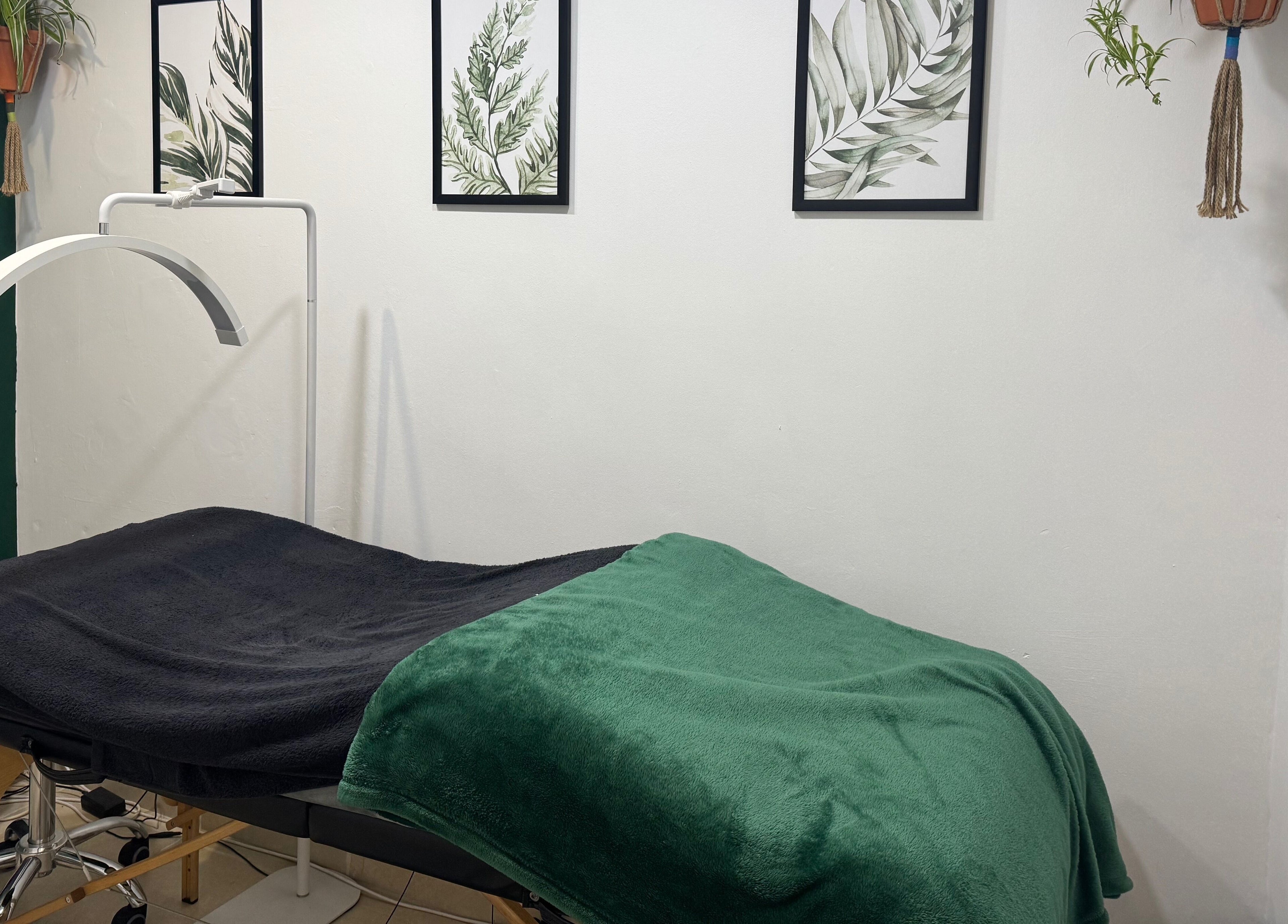 Tranquil treatment room at Studio 48, Randburg, Gauteng, ZA showing a massage bed with green accents.