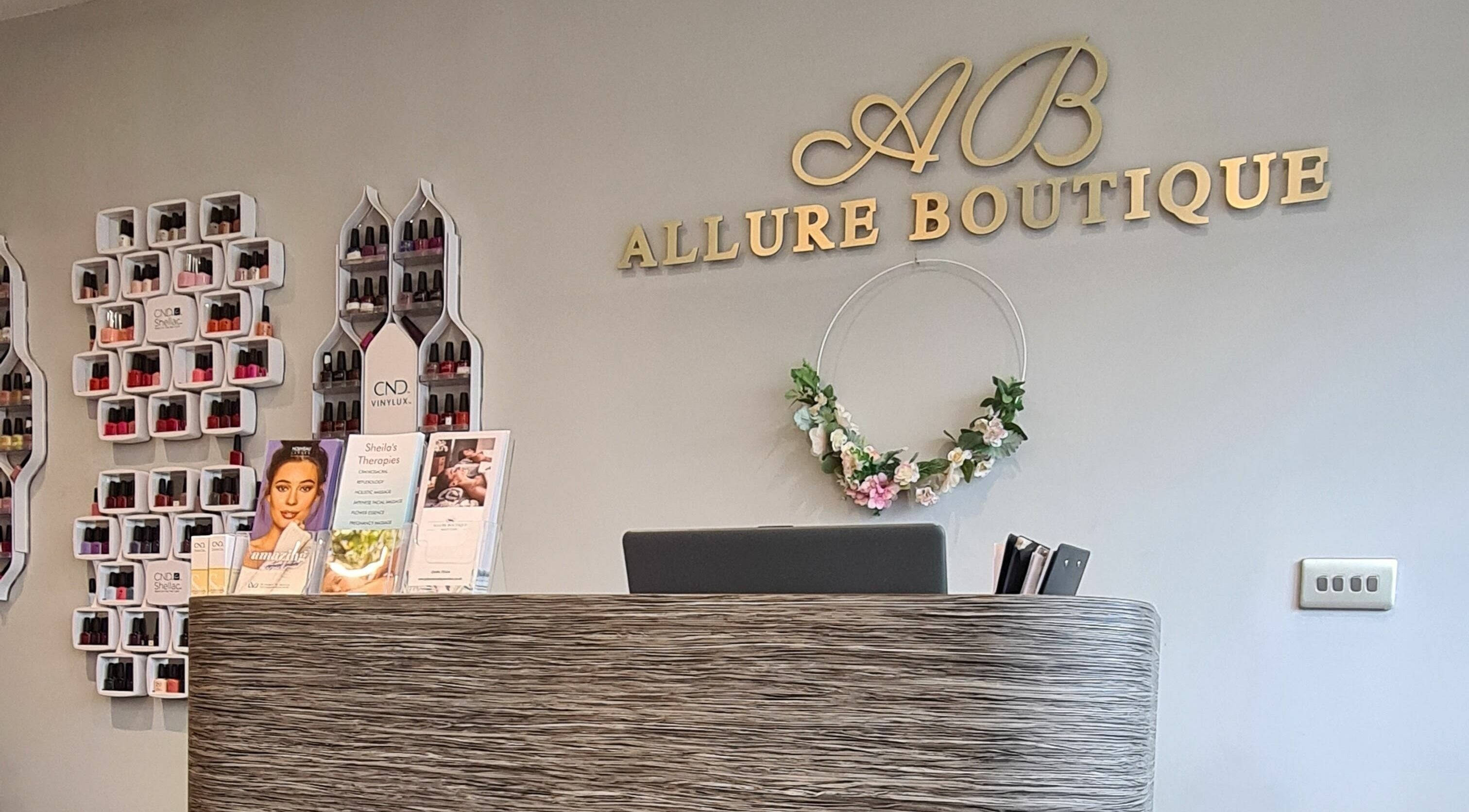 Elegant reception desk at Allure Boutique, High Wycombe, England, GB, with stylish decor and nail polish displays.