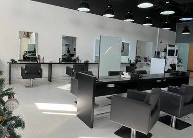 Modern interior of Rami Makeover Hair and Beauty Salon in DIFC, Dubai, AE, with stylish chairs and mirrors.
