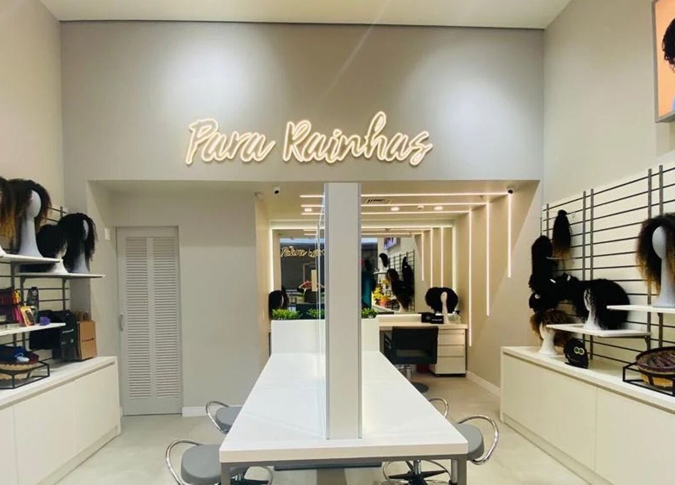 Interior da Loja Tatuapé em São Paulo, São Paulo, BR, exibindo manequins e perucas elegantes em prateleiras iluminadas.