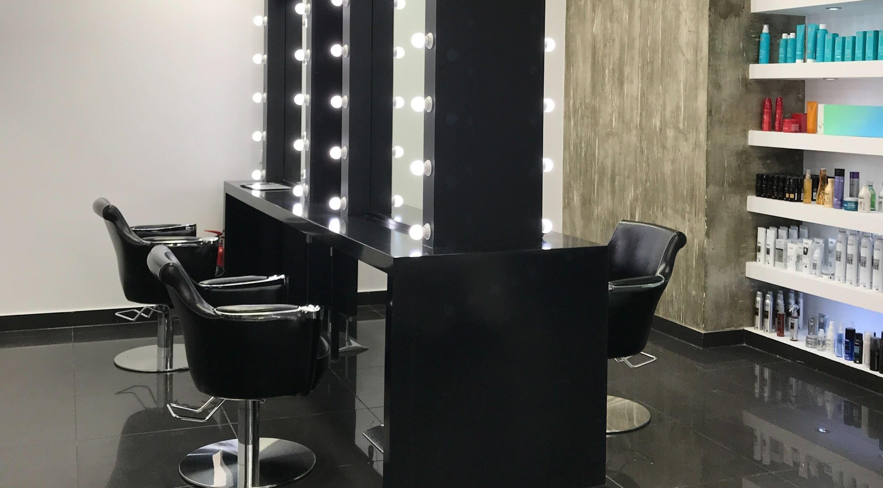 Κομψό εσωτερικό με καθρέφτες και προϊόντα ομορφιάς στο Ikonomakis Hair and Beauty Experts, Χαλάνδρι, GR.