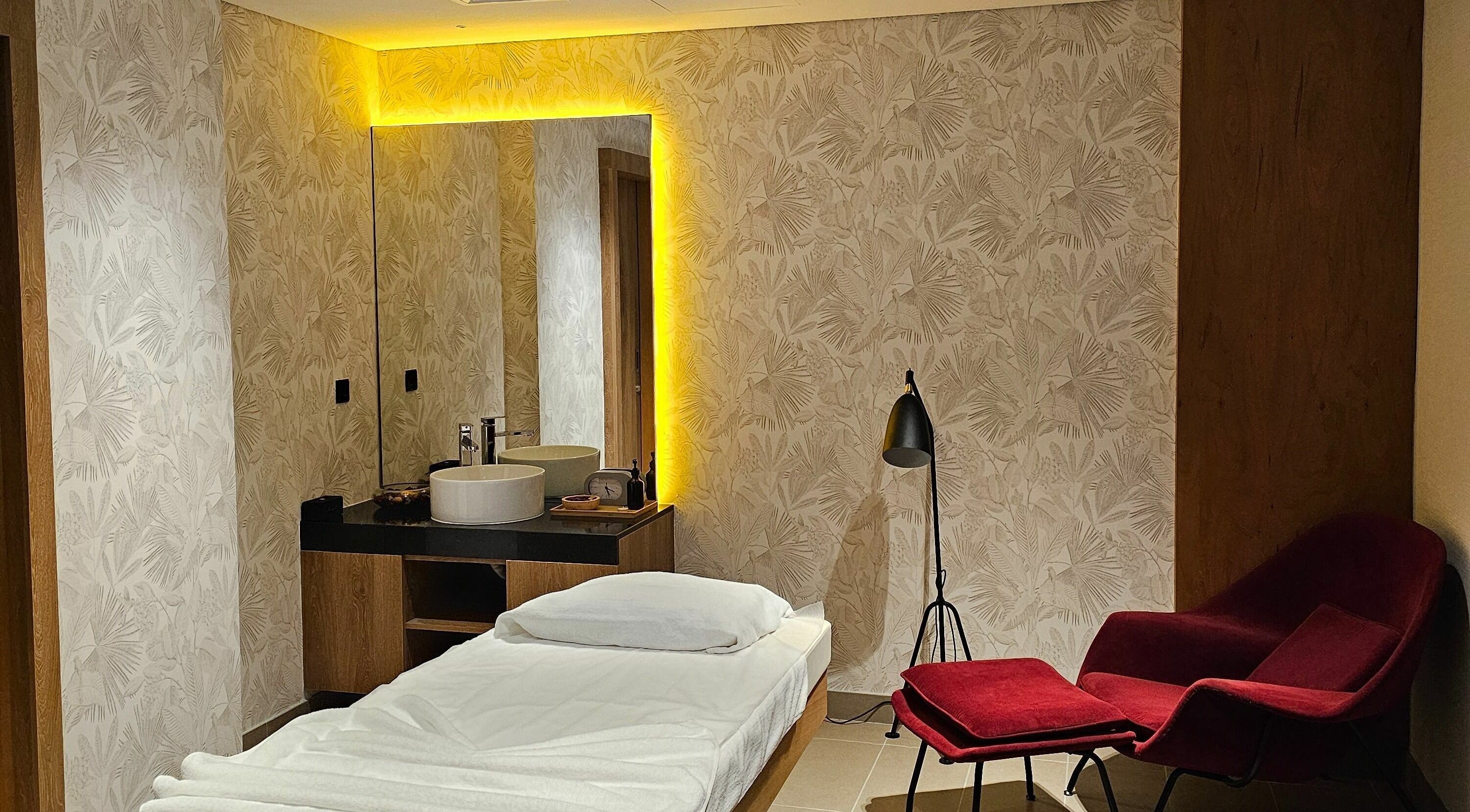 Versailles Spa - Aloft Airport Hotel massage room in Dubai featuring a cozy bed and calming decor.